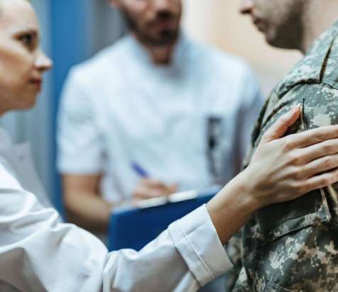 closeup-soldier-being-consoled-by-healthcare-workers-clinic